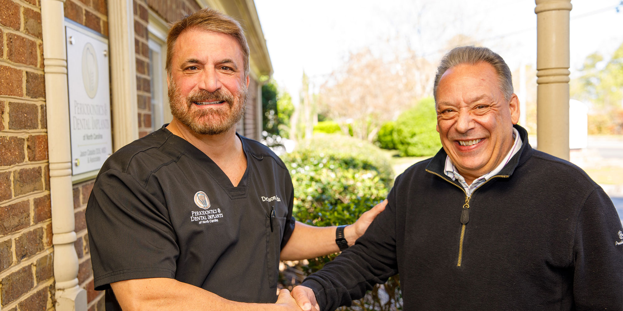 doctor and patient shaking hands outside of the dental center